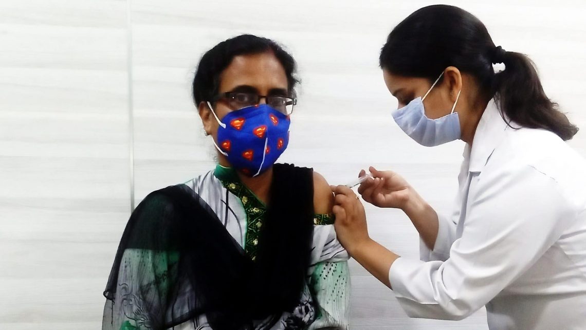 Eine Frau in Delhi erhält ihre erste Coronaschutzimpfung.